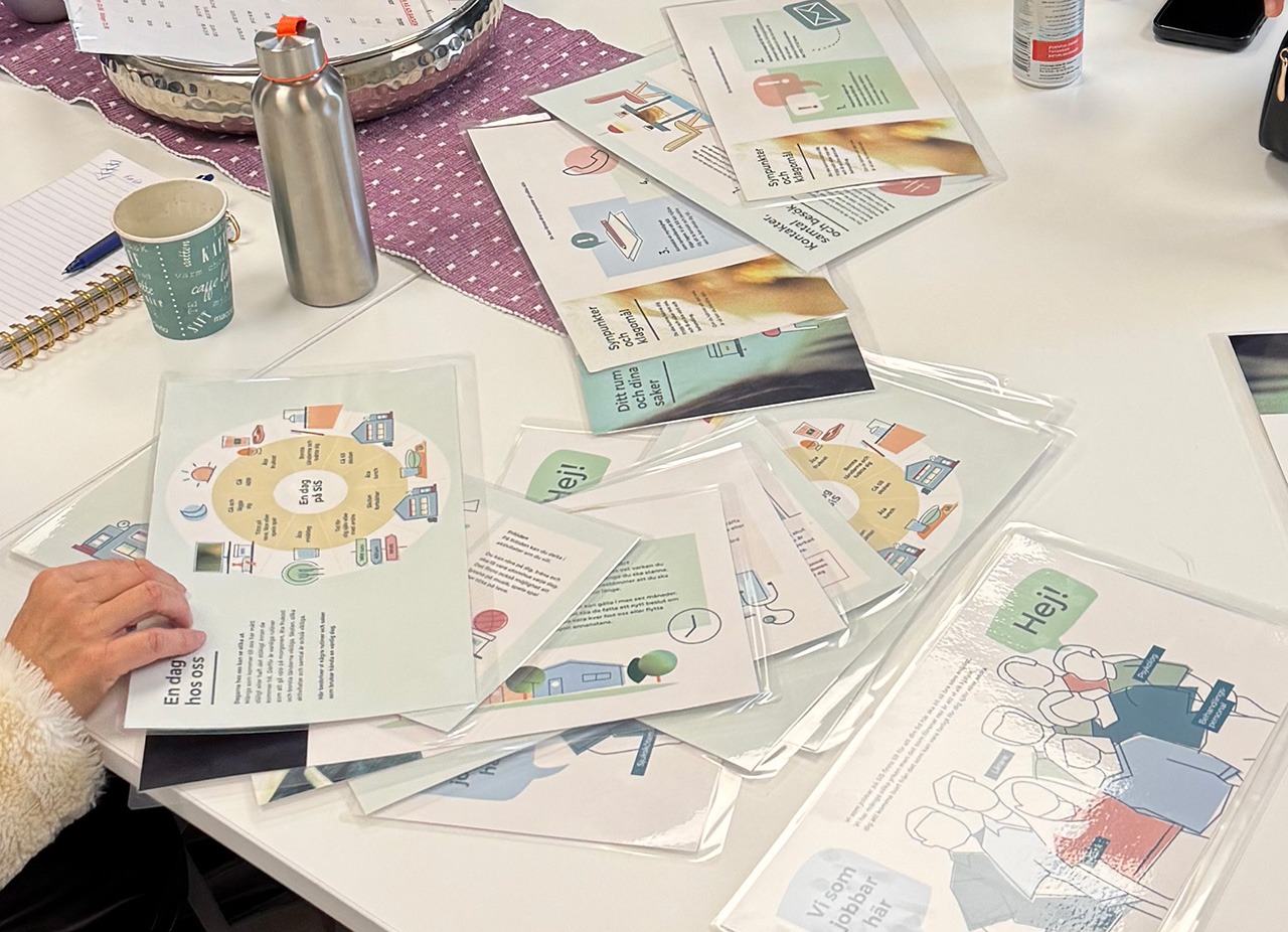 En medarbetare bläddrar i bildstödsmaterialet som ligger på ett bord.